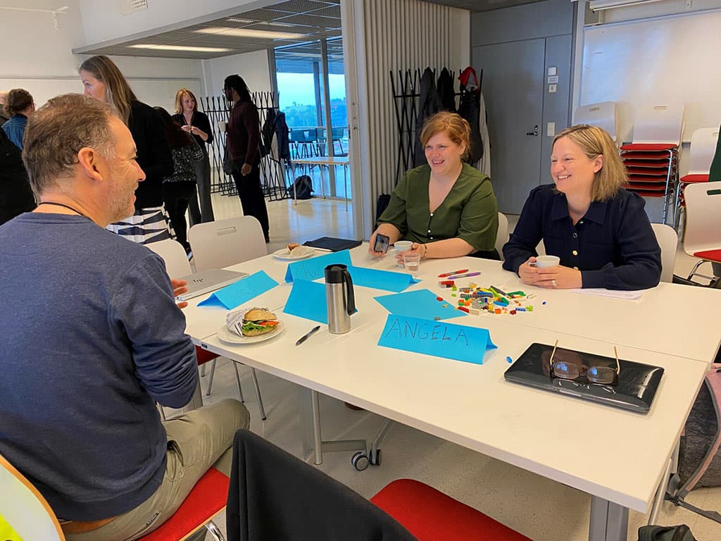 Seminar attendees laughing around a table